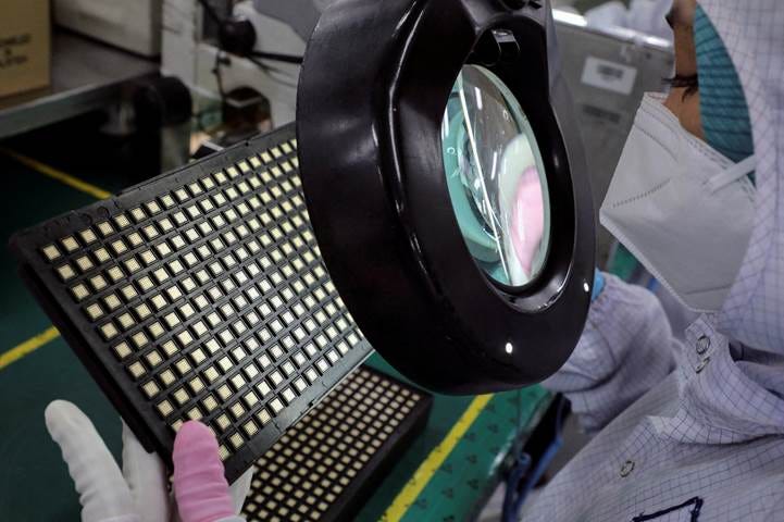 A worker inspects semiconductor chips at the chip packaging firm Unisem (M) Berhad plant in Ipoh, Malaysia October 15, 2021. REUTERS/Lim Huey Teng/File Photo