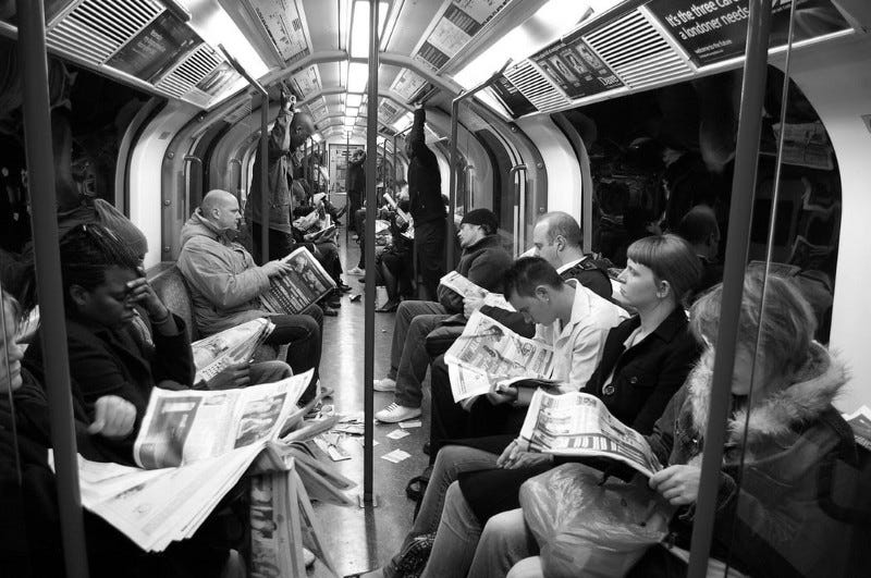 people reading newspapers on the subway