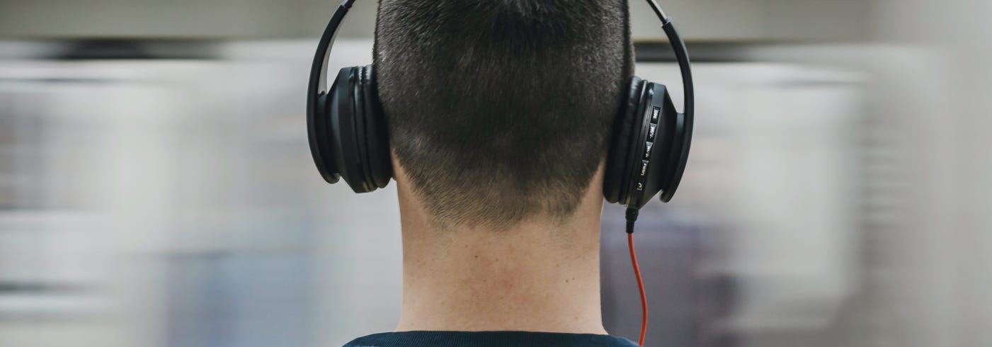 A guy on the Metro with Headphones and a Blurred background