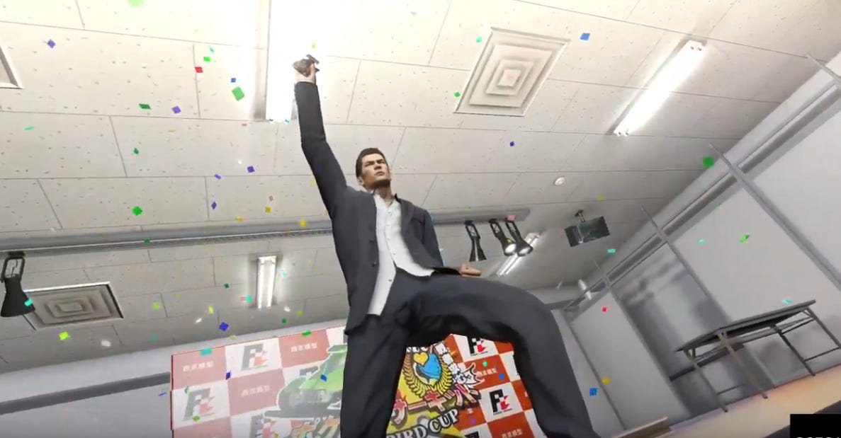 Kiryu, wearing a suit, triumphantly cheering and holding a tiny remote controlled car and surrounded by confetti.