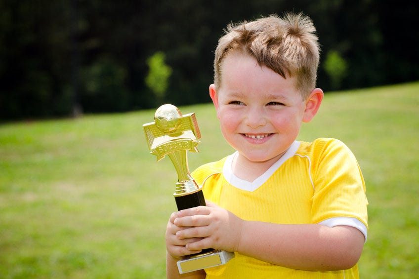 Young soccer player holding a trophy