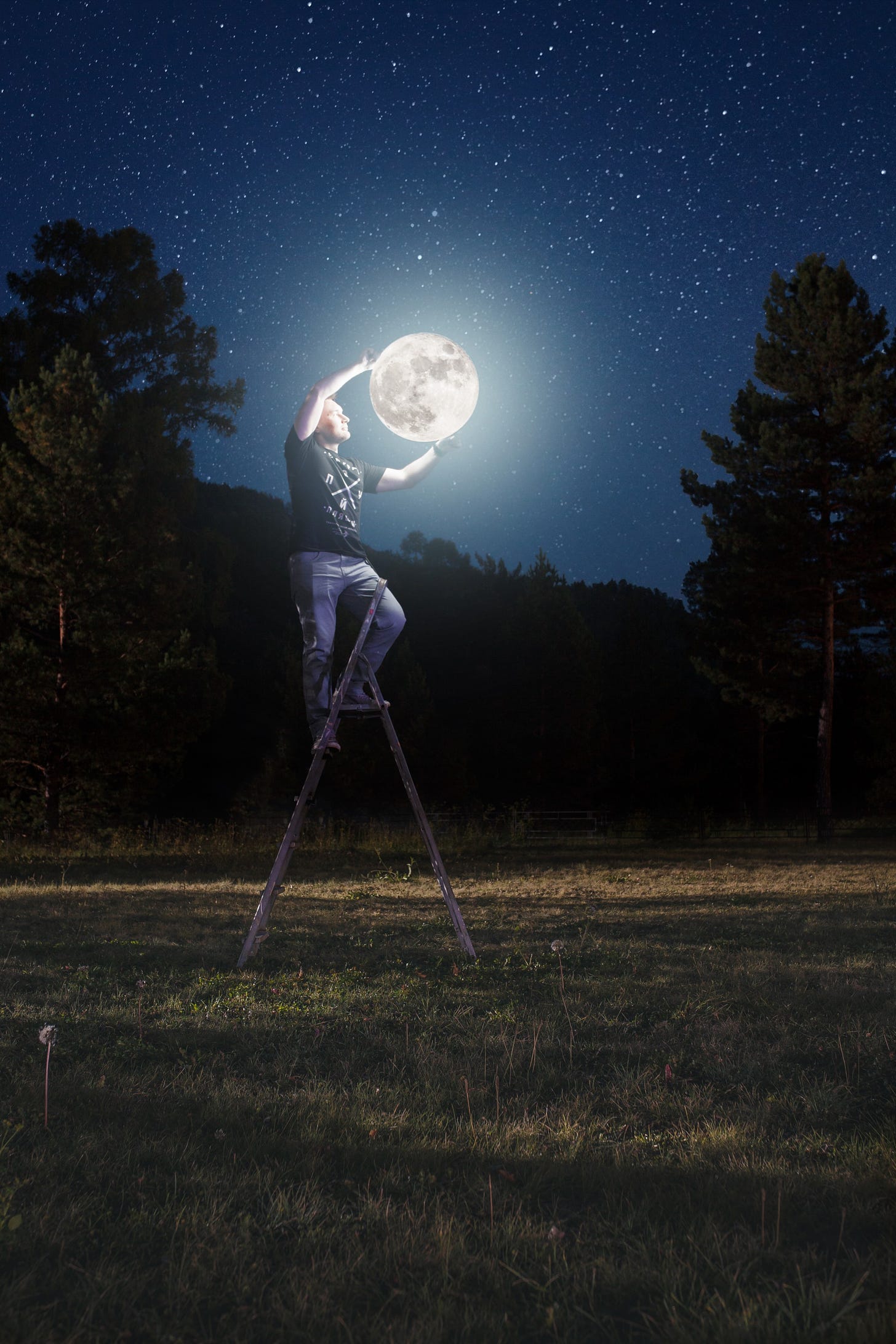 A man on a ladder poses so it appears he is holding the moon in his arms.