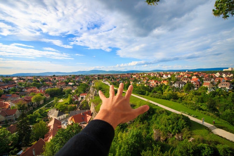 Hand reaching to town