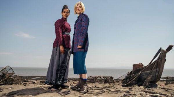 This image shows Yaz Khan (played by Mandip Gill) and the Thirteenth Doctor (played by Jodie Whittaker) standing on a Chinese beach in the year 1807. Both face the camera and stand close together, with Yaz on the left and the Doctor on the right. This image shows Yaz Khan (played by Mandip Gill) and the Thirteenth Doctor (played by Jodie Whittaker) standing on a Chinese beach in the year 1807. Both face the camera and stand close together, with Yaz on the left and the Doctor on the right.