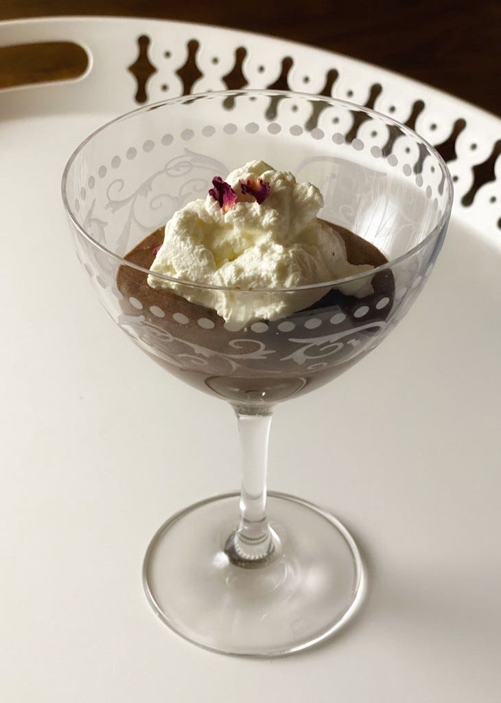 Chocolate mousse served in an etched Champagne coupe, topped with whipped cream and dried rose petals