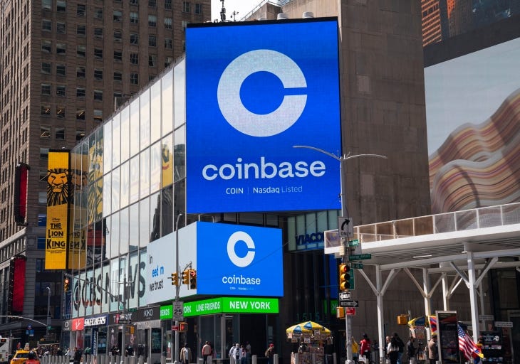 Monitors display Coinbase signage during the company's initial public offering