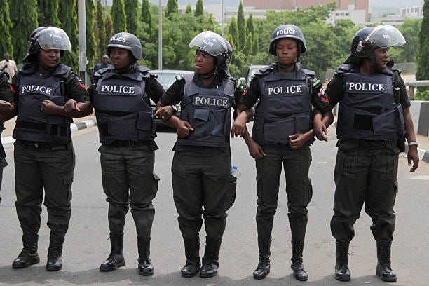 Police women link arms to stop protesters from advancing to the presidency as people gather to press for the release of the missing Chibok...