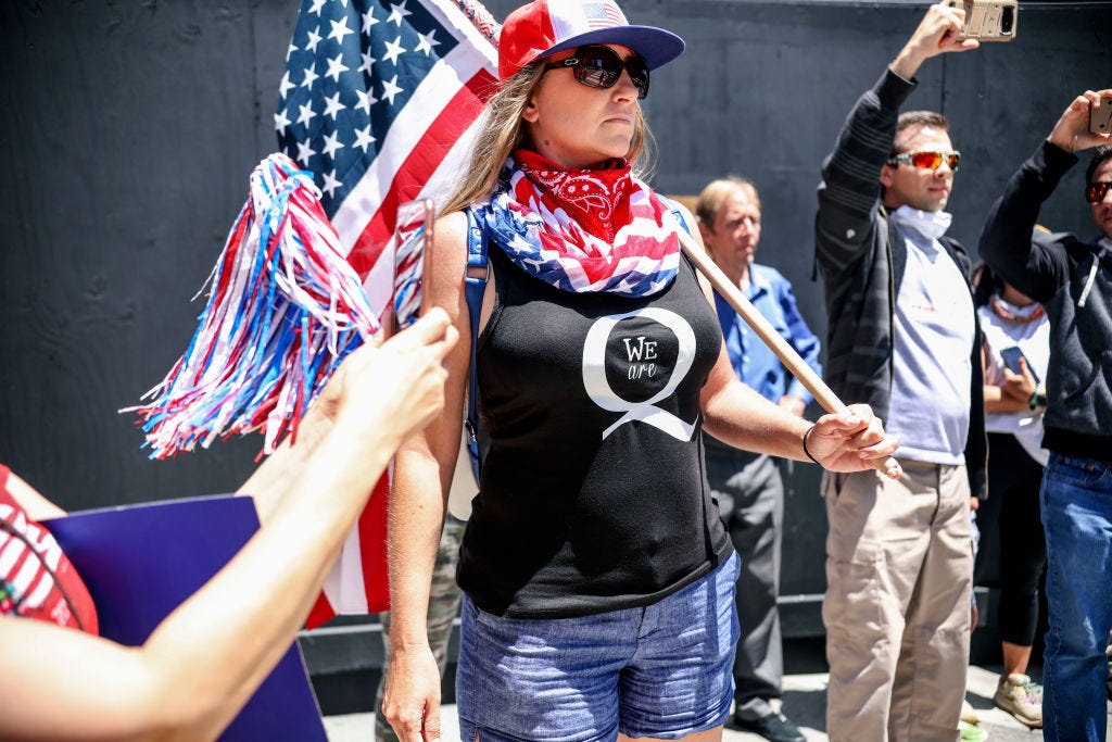 Conspiracy theorist QAnon demonstrators protest during a rally to re-open California and against Stay-At-Home directives on May 1, 2020 in San Diego, California. - Rallies have been held at several state capitols across the country as protesters express their deep frustration with the stay-at-home orders that are meant to stem the spread of the novel coronavirus. (Photo by Sandy Huffaker / AFP) (Photo by SANDY HUFFAKER/AFP via Getty Images)