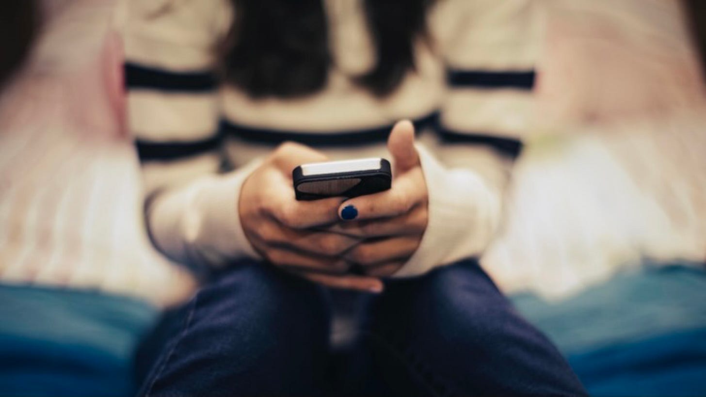 Close up of teenage girl in bedroom using smart phone The Good Brigade via Getty Images