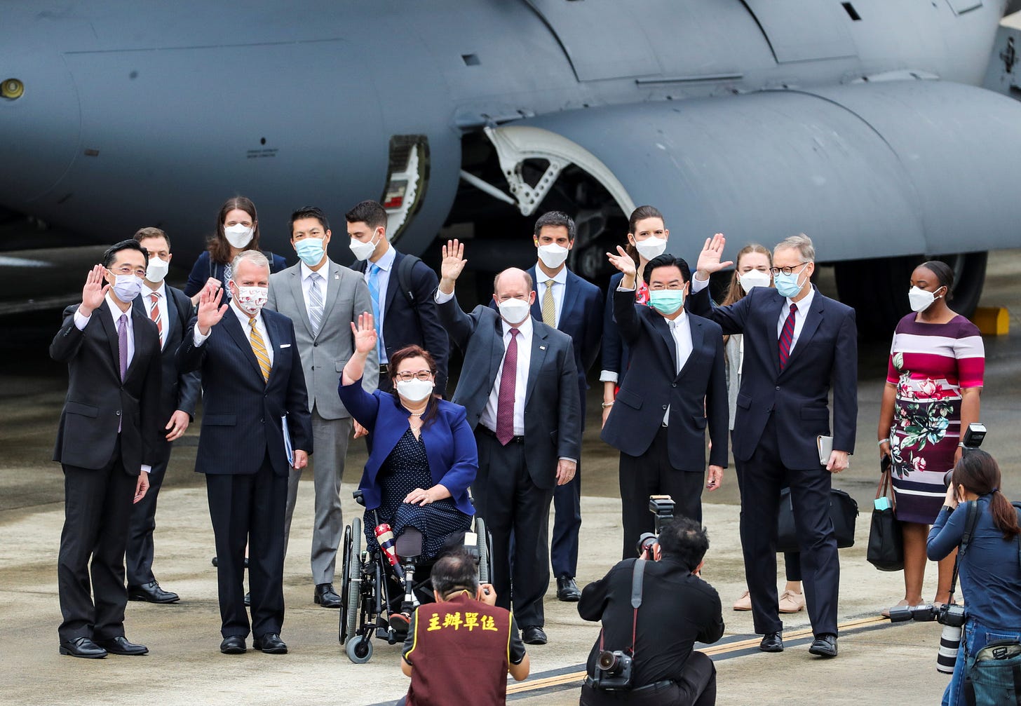 U.S. Senators Tammy Duckworth (D-IL), Dan Sullivan (R-AK) and Chris Coons (D-DE) wave next to Taiwan Foreign Minister Joseph Wu and Brent Christensen, director of the American Institute in Taiwan, after their arrival via a U.S. Air Force freighter at Taipei Songshan Airport in Taipei, Taiwan June 6, 2021. Central News Agency/Pool via REUTERS