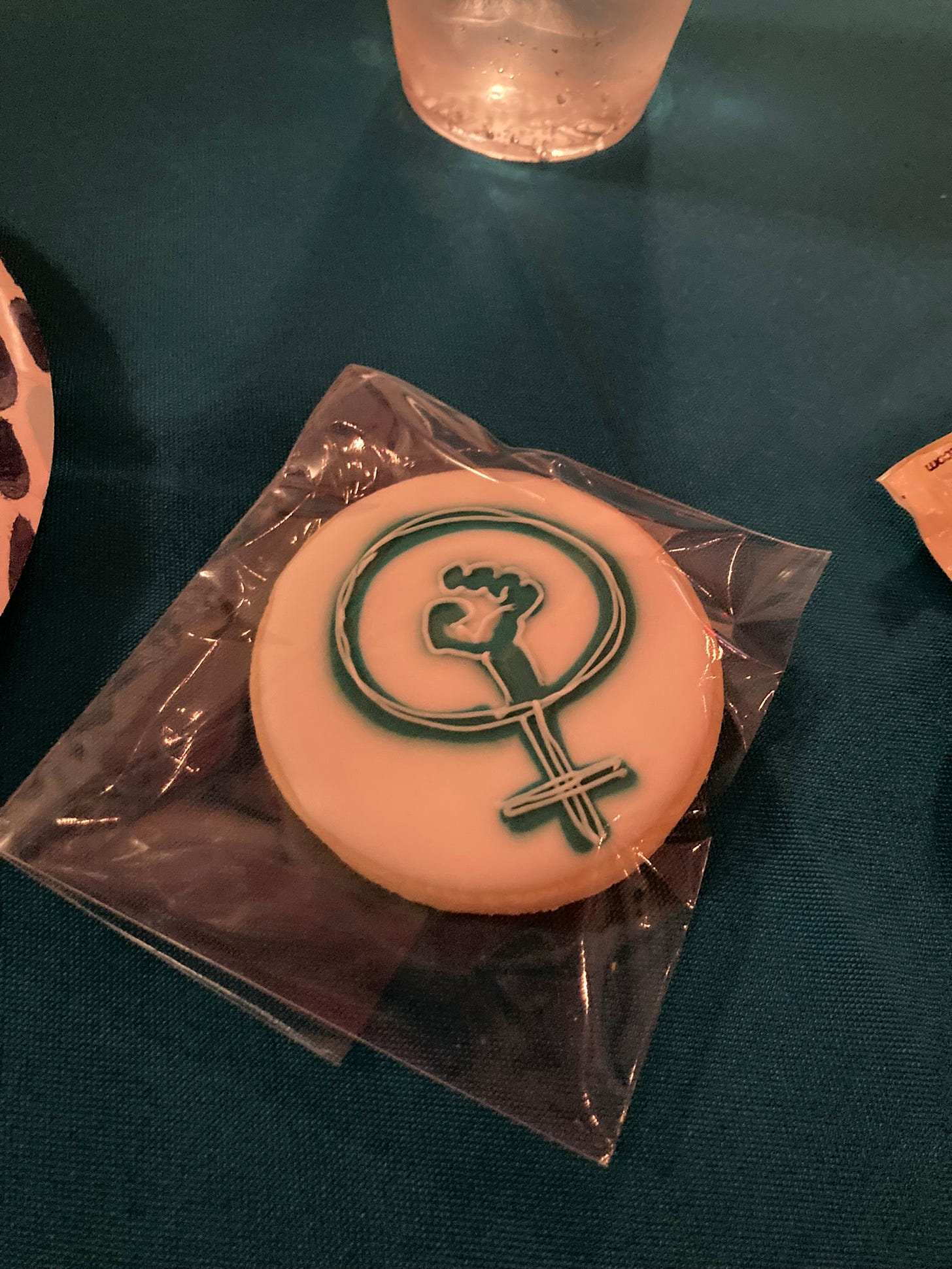 An iced cookie with a design of the symbol for women with a fist in the circle