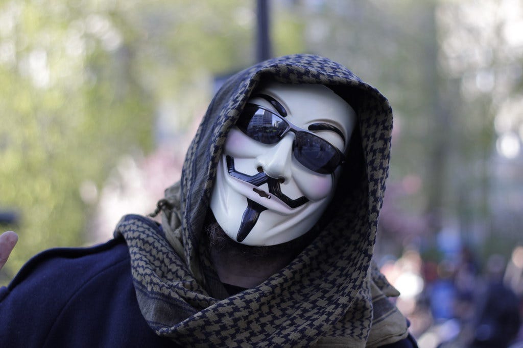"Man in Guy Fawkes mask at Occupy Wall Street" by WarmSleepy is licensed under CC BY 2.0