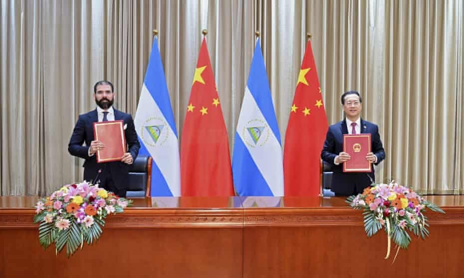 Representatives for Nicaragua and China display their jointly signed communique on the resumption of diplomatic relations 