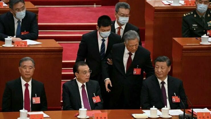 El expresidente chino Hu Jintao es escoltado fuera de la clausura del Congreso del Partido Comunista