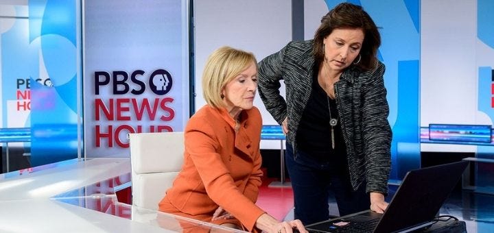 Judy Woodruff and Sara Just looking at a laptop in the studio