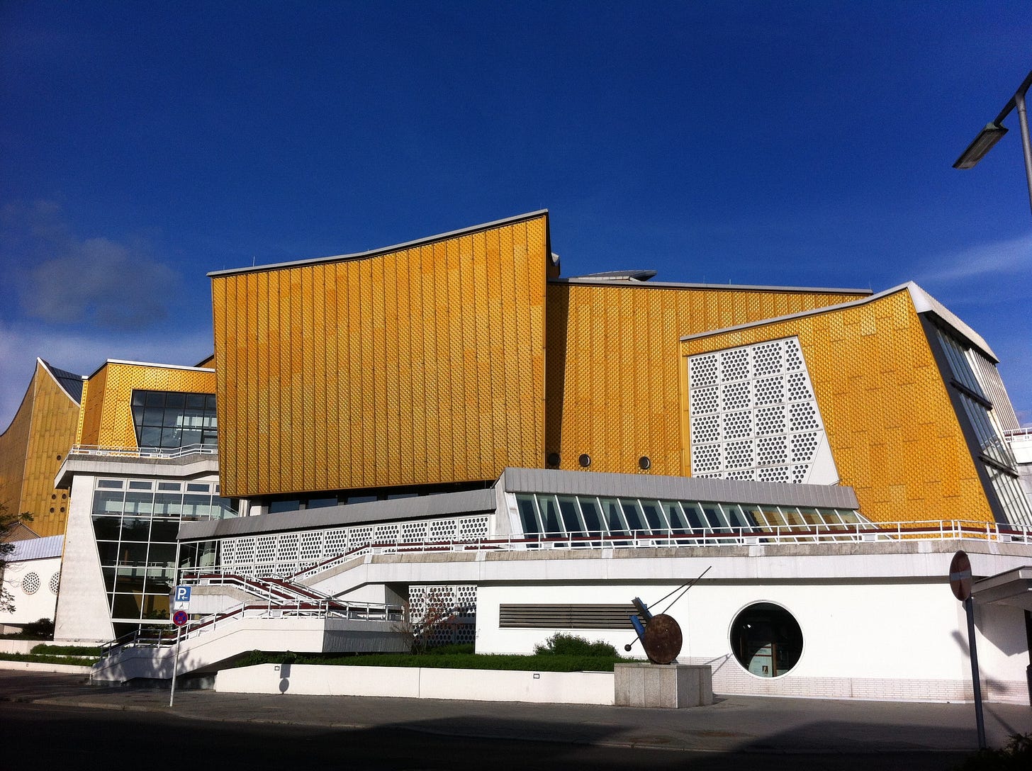 Yellow and white modernist building with roofline at multiple angles.