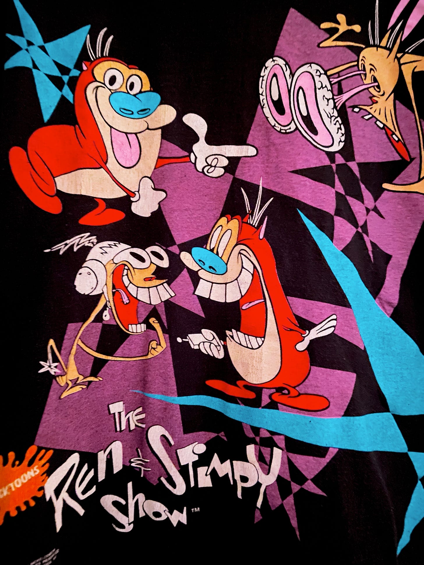 A close-up of the hijinks and antics of Ren & Stimpy as featured on a tee; you can see the show's name card.