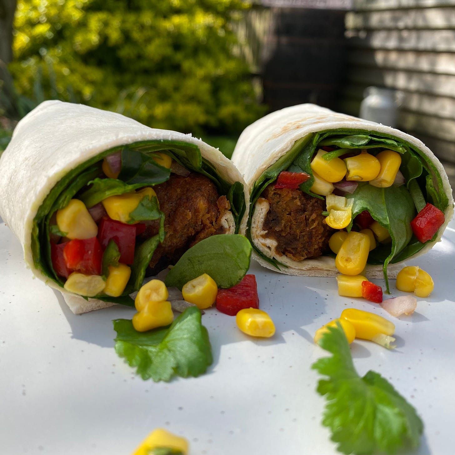 Tortilla wrap sandwich filled with falafel, sweetcorn, spinach and coriander