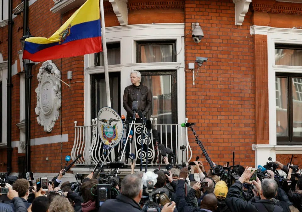 Watched by the media WikiLeaks founder Julian Assange looks out from the balcony of the Ecuadorian embassy prior to speaking, in London on May 19, 2017. (Matt Dunham/AP)