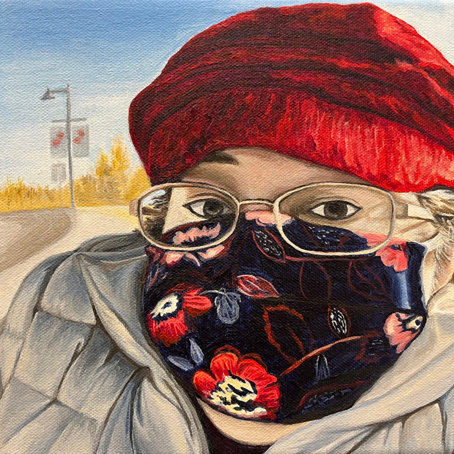 Painting of head and shoulders figure wearing a mask and bundled up for a chilly day. She wears a knitted red cap, rectangular glasses and a dark blue mask with a red floral print. Her dark eyes gaze directly and intensely at the viewer. The sky behind her bright blue and the street winds around a corner away from her and is punctuated with street lamps that have banners with poppies on them.