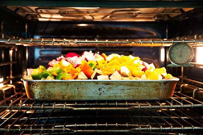 A pan of vegetables in the oven. 