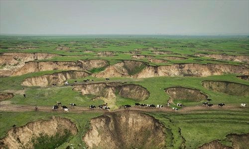 Grassland at a coal mine in Baorixile, Inner Mongolia, is dotted with pits left by ruthless exploration over the past few decades. Photo: Lu Guang, courtesy of Greenpeace