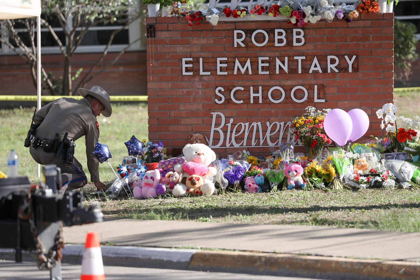 A view from the makeshift memorial in front of Robb Elementary School in Uvalde, Texas, on May 25, 2022. Flowers are placed on a makeshift memorial. - The tight-knit Latino community of Uvalde was wracked with grief Wednesday after a teen in body armor marched into the school and killed 19 children and two teachers, in the latest spasm of deadly gun violence in the US. Texas state troopers outside Robb Elementary School 19 students and one teacher were killed during a massacre in a Texas elementary school, the deadliest US school shooting. (Photo by Yasin Ozturk/Anadolu Agency via Getty Images)
