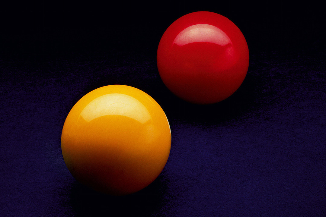 Photo of a red and a yellow billiard ball