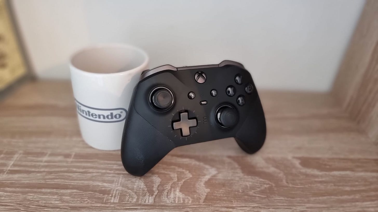 Xbox Elite Series 2 Wireless Controller leaning against a Nintendo mug
