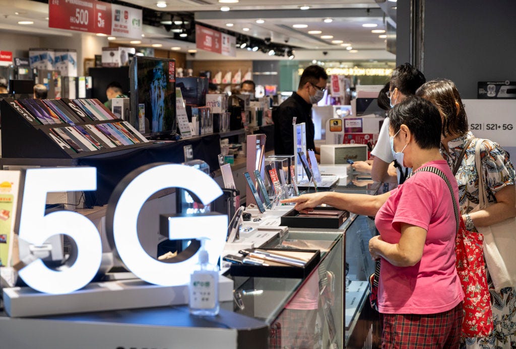 Shoppers are seen at an electronic store displaying mobile