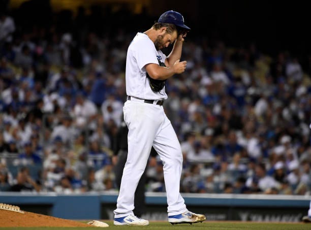 Starting pitcher Clayton Kershaw of the Los Angeles Dodgers adjust his baseball cap after giving a two hits to the Chicago Cubs during the fifth...