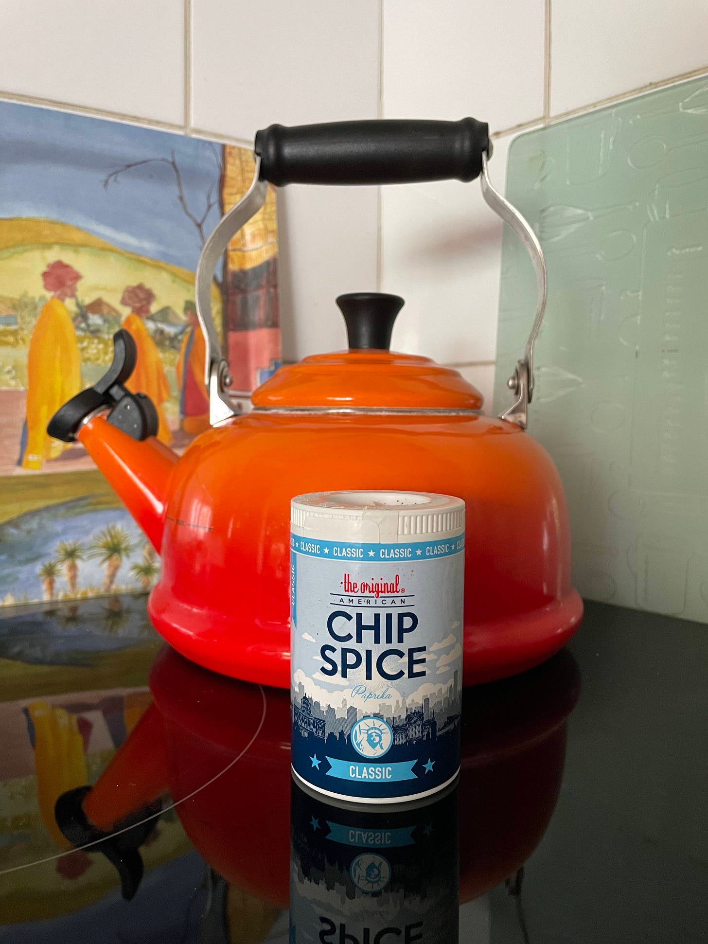 Colour photo showing an orange whistle kettle in the background and a jar of The Original American Chip Spice