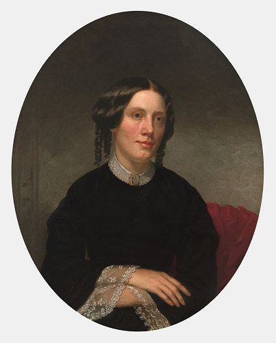 white woman in dark dress with lace collar and cuffs. Her hands are folded. Her hair is rolled over her ears with ringlets hanging at the back