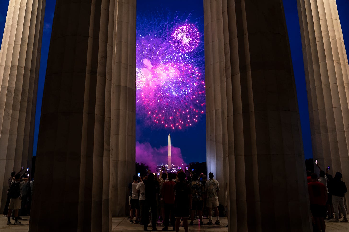 Spectators watch as fireworks erupt over the Washington Monument on July 4, 2022 in Washington, DC. (Photo by Nathan Howard/Getty Images)