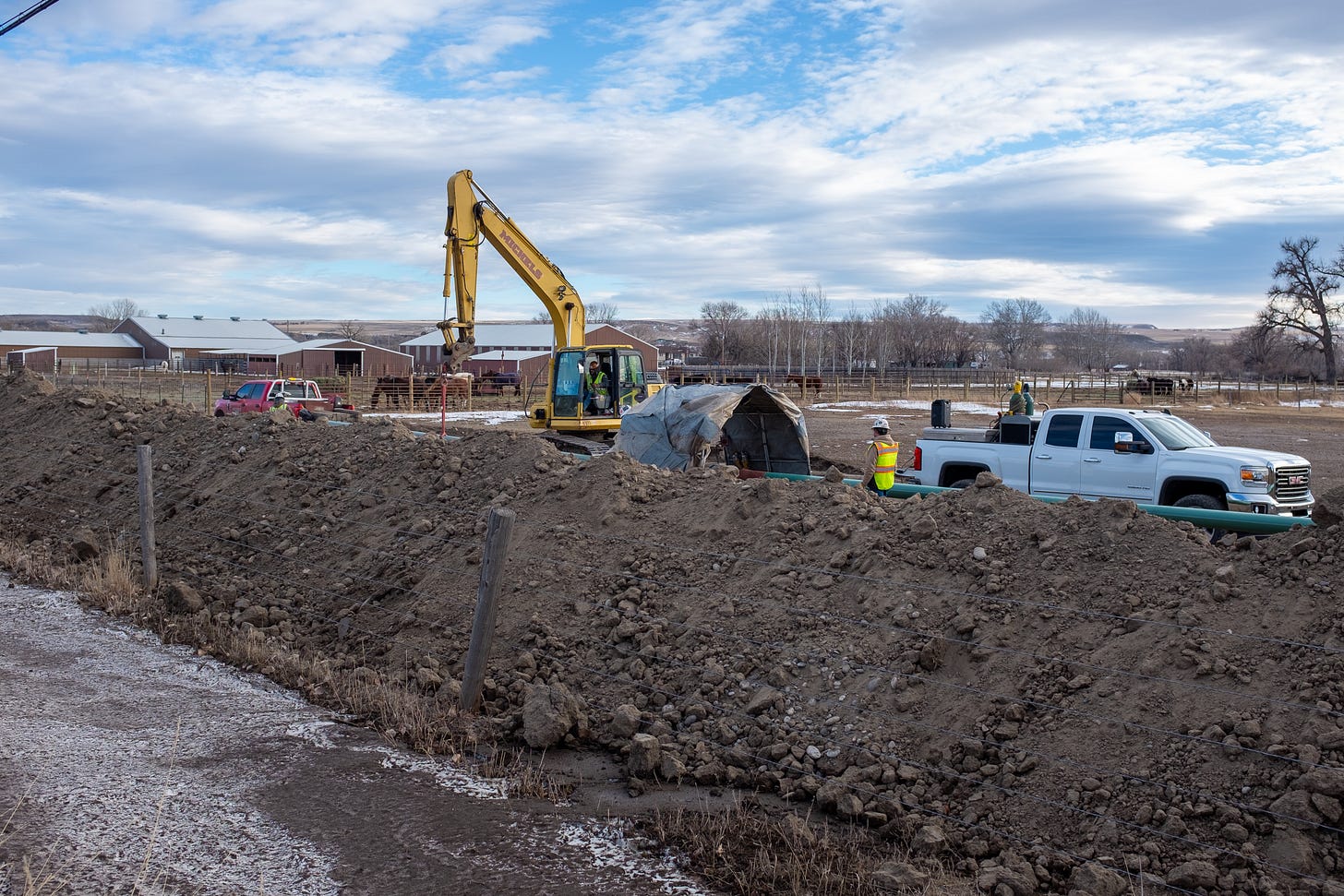 Excavator operating next to farmland