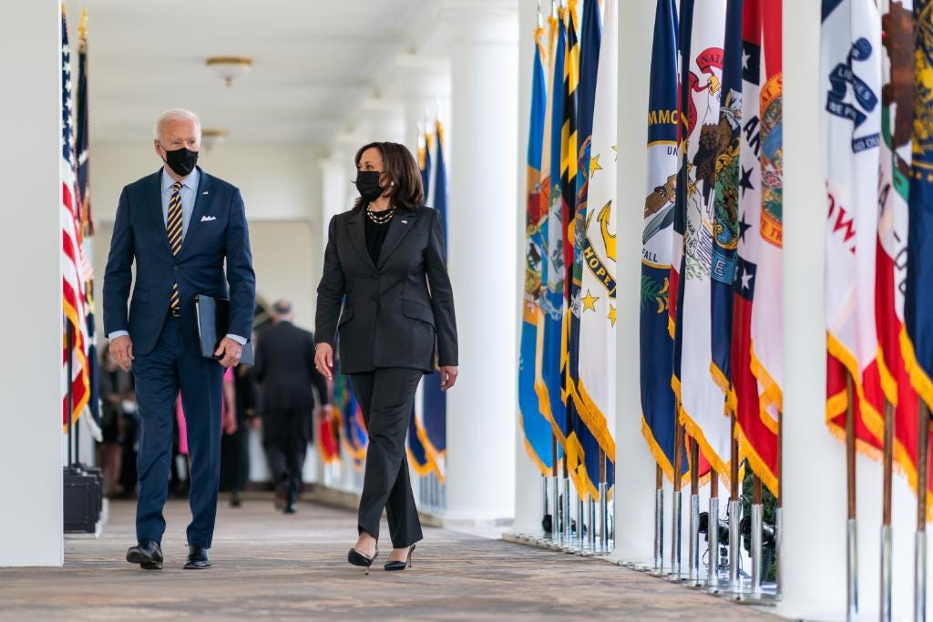 President Biden and Vice President Harris walk along the White House