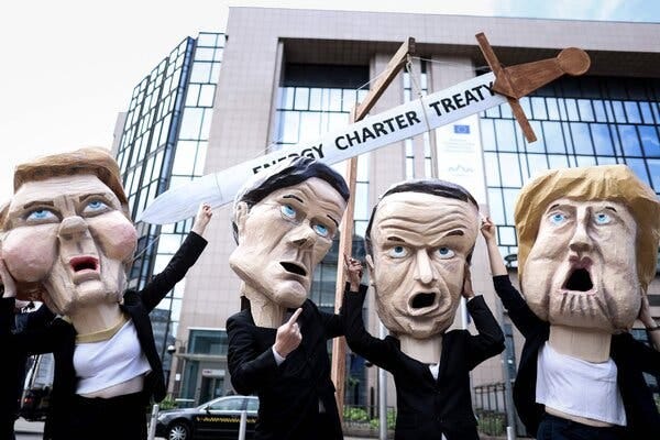 Environmental activists, wearing masks in the likeness of E.U. leaders, outside the European Council building in Brussels on Tuesday.