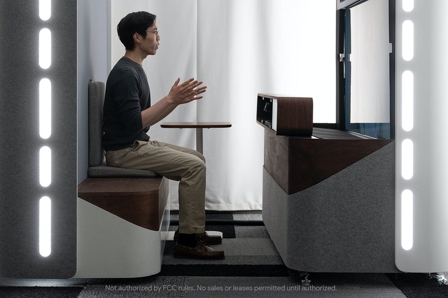 A person sits at one of Google’s Project Starline 3D video chat booths.