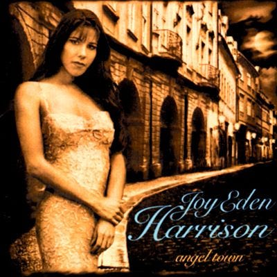 Album cover, a sepia-toned photo of the artist standing on a sidewalk in front of a row of buildings.