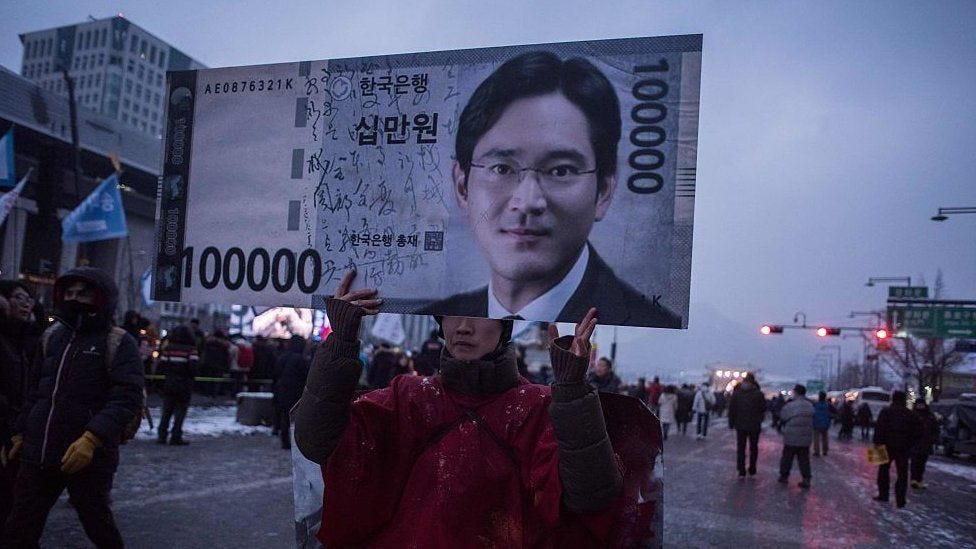A protester holds up a placard with Samsun heir Lee Jae-yong's face on it in an anti-government corruption protest in 2o017