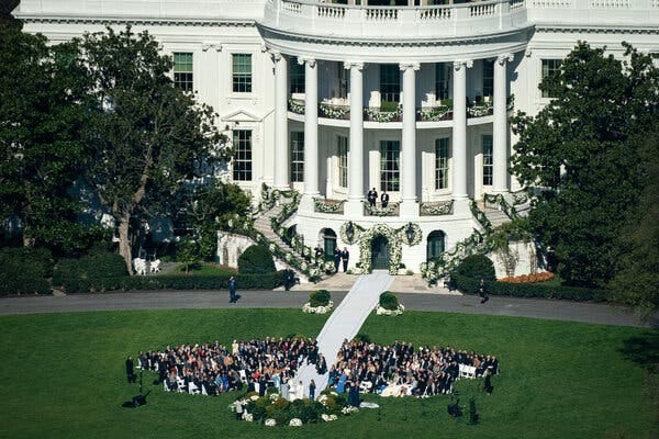 An aerial view of the White House, which has flowers decking its south-facing balconies, stairs and main doorway.