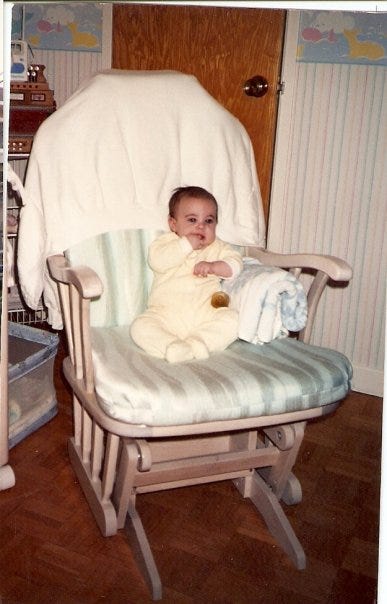 Cassandra as a baby on a rocking chair.