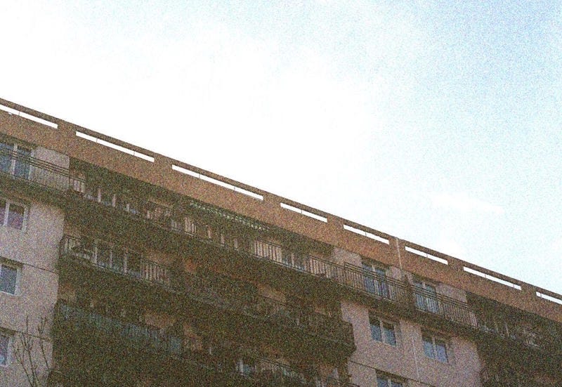 Film photo of building’s top floors and blue sky