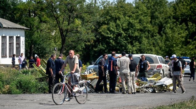 Des enquêteurs contemplent les débris du Boeing de la Malaysia Airlines abattu au-dessus de l'Ukraine, près du village de Hrabove, le 25 juin 2014