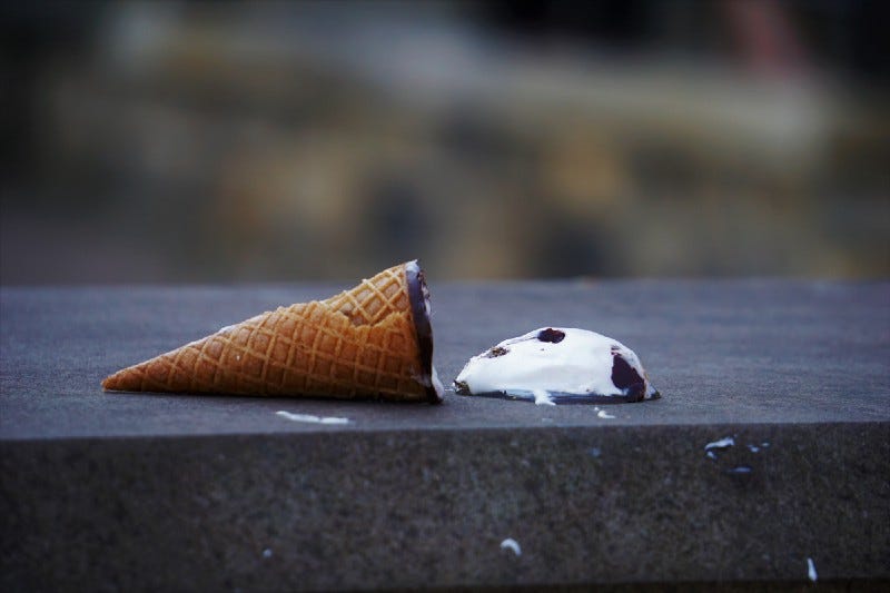 An ice cream with a scoop on the floor