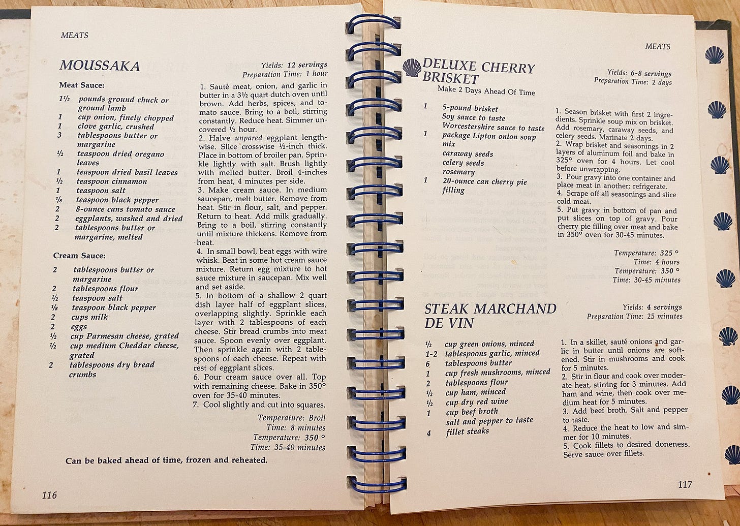 photo of a two-page cookbook spread, with recipes for moussaka, deluxe cherry brisket, and steak marchand de vin