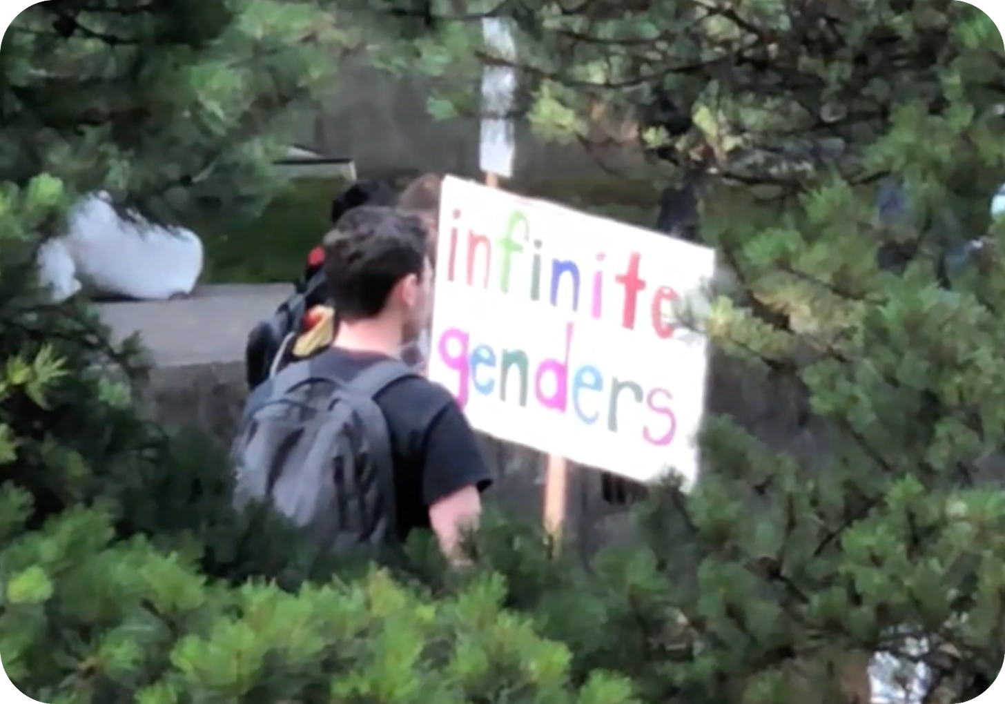 Portland protestor holding sign that reads "infinite genders"