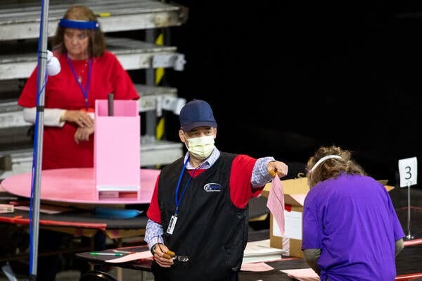 Contractors working for a group hired by Republican state senators examined ballots from the 2020 general election at Veterans Memorial Coliseum in Phoenix this week.
