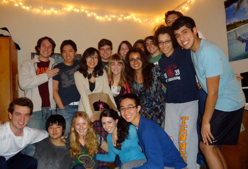 Kevin posing with a group of classmates in a dorm.