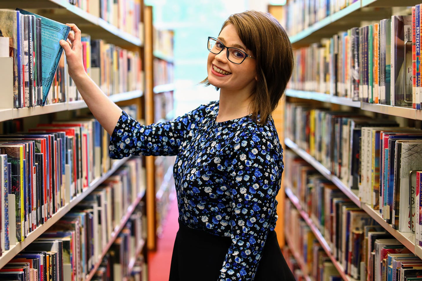 A portrait of librarian Morgan Green-Griffin in the stacks at the Cozby Library